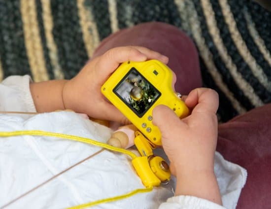 niña con cámara de juguete digital en las manos