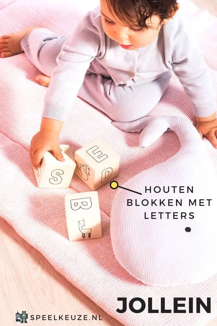 Meisje speelt met Jollein houten blokken met letters in kinderkamer
