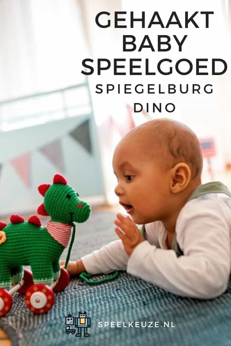 Photo of baby on bed with the crocheted Spiegelburg dino pull toy