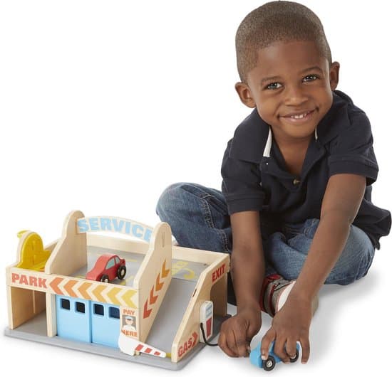 Boy plays with the cars and doors of the Melissa & Doug parking garage