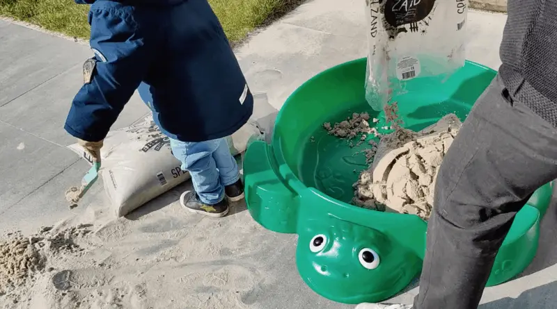 Little Tikes turtle sandbox is filled with bags of sand