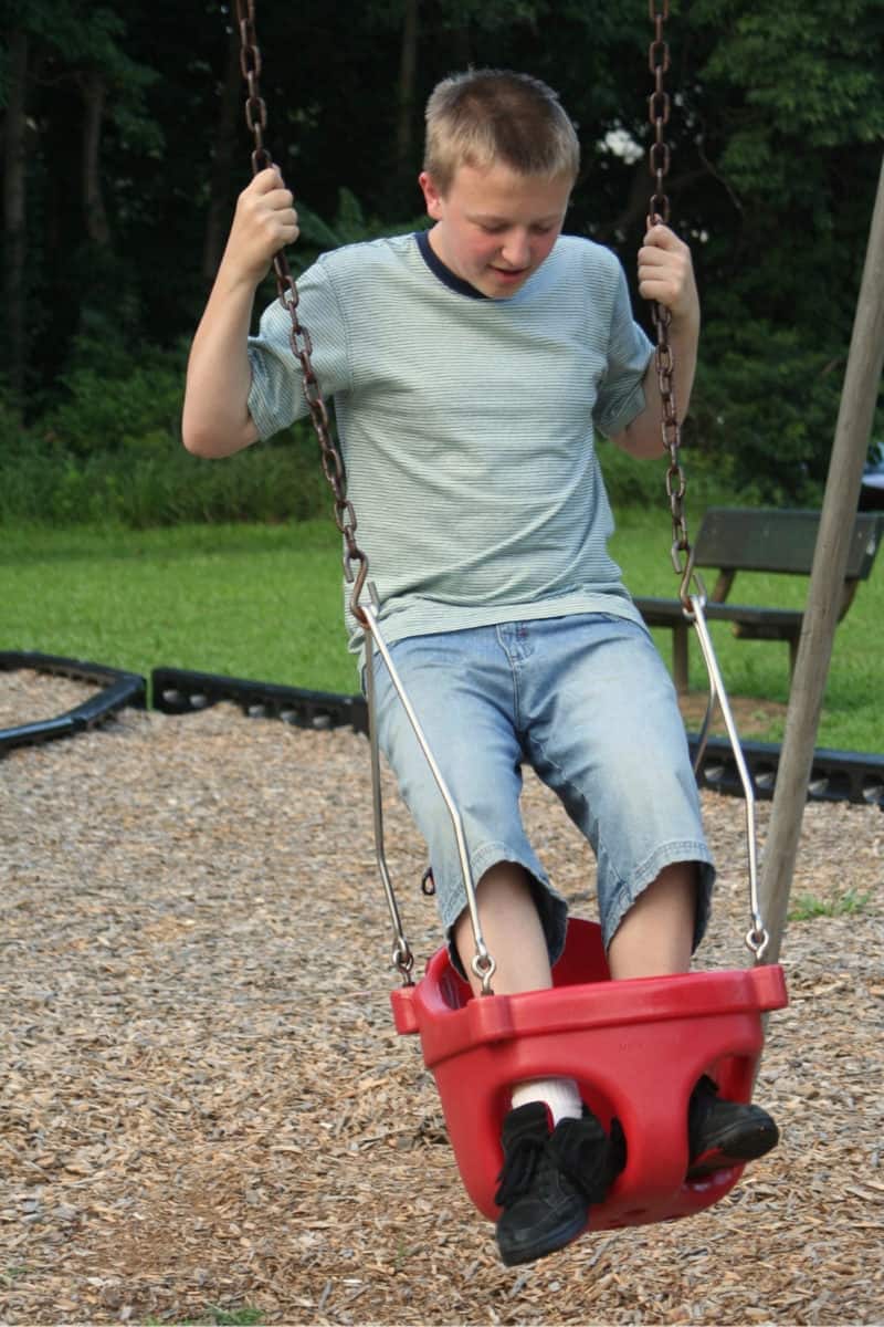 Way too old boy on a toddler swing