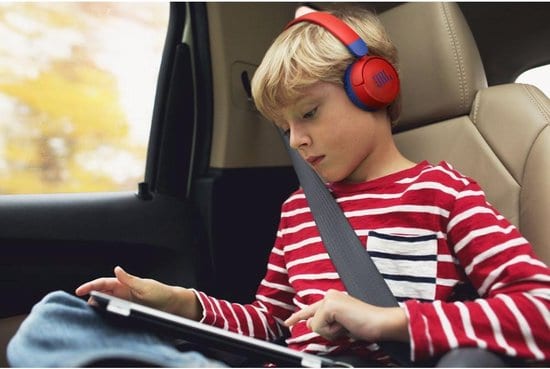 Boy in a car wearing the JBL JR310BT children's headphones