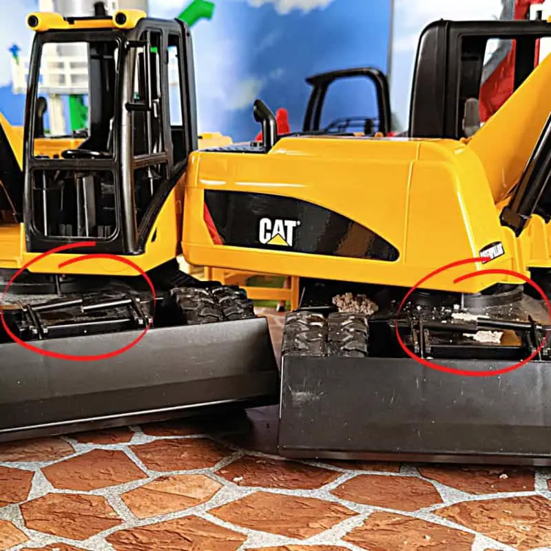 Photo of two Bruder Cat excavators with a broken bar