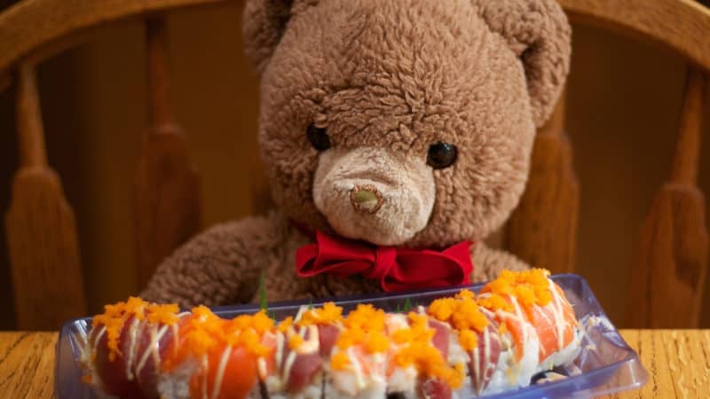 Speelgoed beer zit klaar om mee te doen met sushi eten