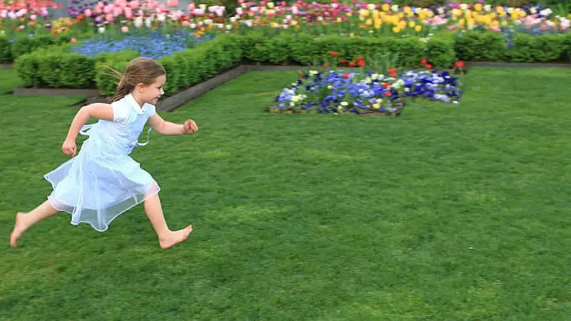 Niña corre sobre la hierba llena de energía