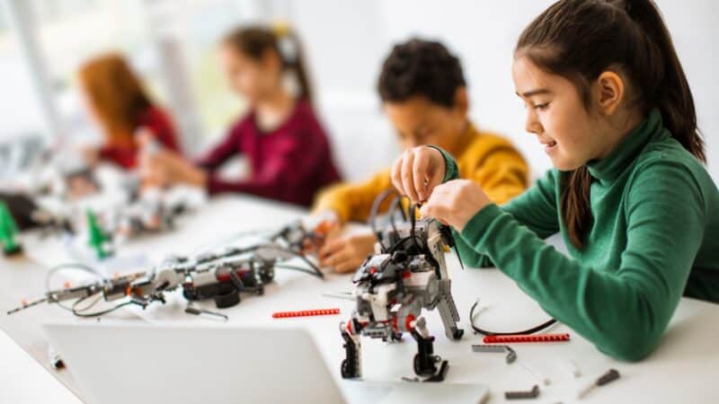 Grupo de niños jugando con juguetes robot