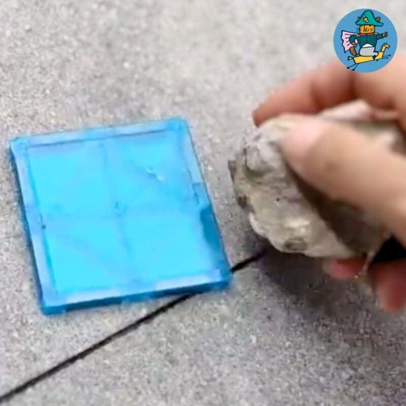 Hier test ik magneet tegels op hun duurzaamheid en veiligheid door er op te slaan met een steen